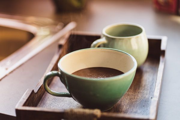 Zwei Tassen auf einem Holztablett